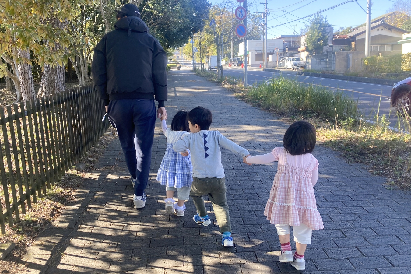 一列で手をつないでいる親子、兄弟の写真